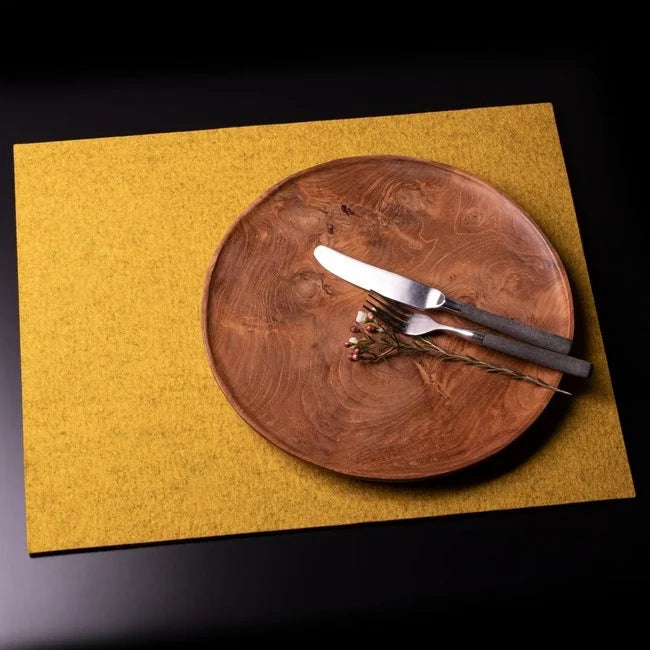 White plate and knife on grey wool felt placemat on white background